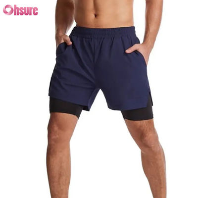 Diseño de logotipo personalizado Poliéster 2 en 1 Calzoncillos de gimnasia Calzoncillos de ejercicios de acondicionamiento físico Ropa de entrenamiento masculina Logotipo estándar Calzoncillos de acondicionamiento físico de línea corta de natación sólida