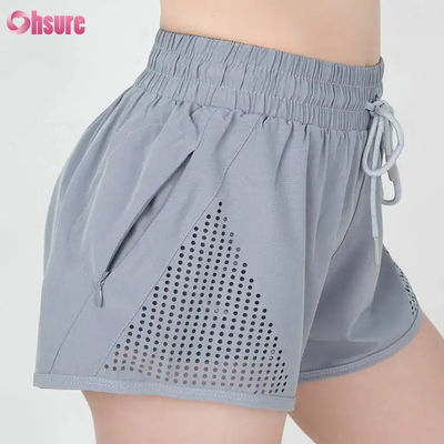 Pantalones cortos deportivos de entrenamiento para mujer al por mayor, transpirables, con corte láser, para correr, con bolsillo lateral con cremallera para calentamiento, patrón sólido
