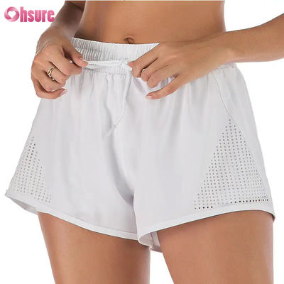 Pantalones cortos deportivos de entrenamiento para mujer al por mayor, transpirables, con corte láser, para correr, con bolsillo lateral con cremallera para calentamiento, patrón sólido